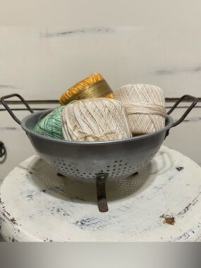 Vintage metal colander + pastel crochet thread bundle.